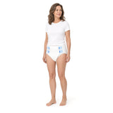 Woman wearing a white adult incontinence brief with refastenable side tabs, front view